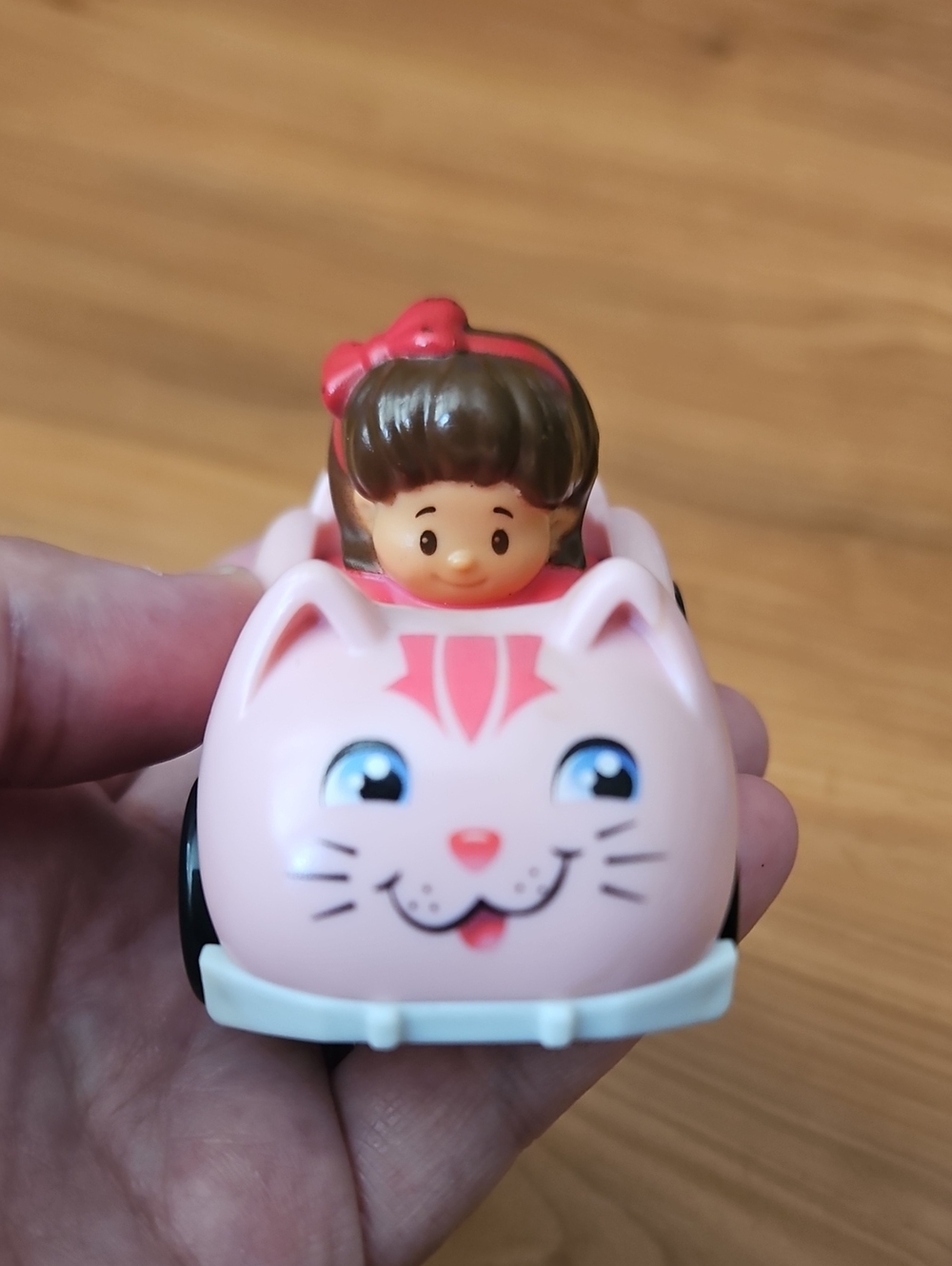 Fisher-Price Little People Wheelies Mia figure seated in a pink cat-shaped car